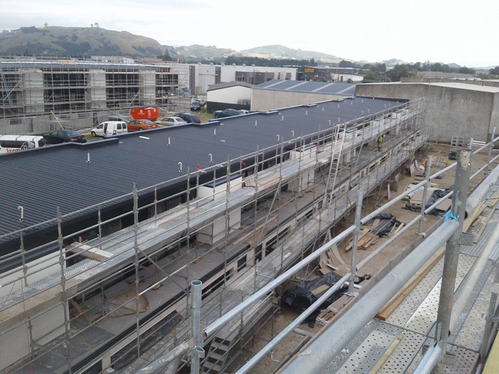 Commercial roofing project with metal roofing and scaffolding